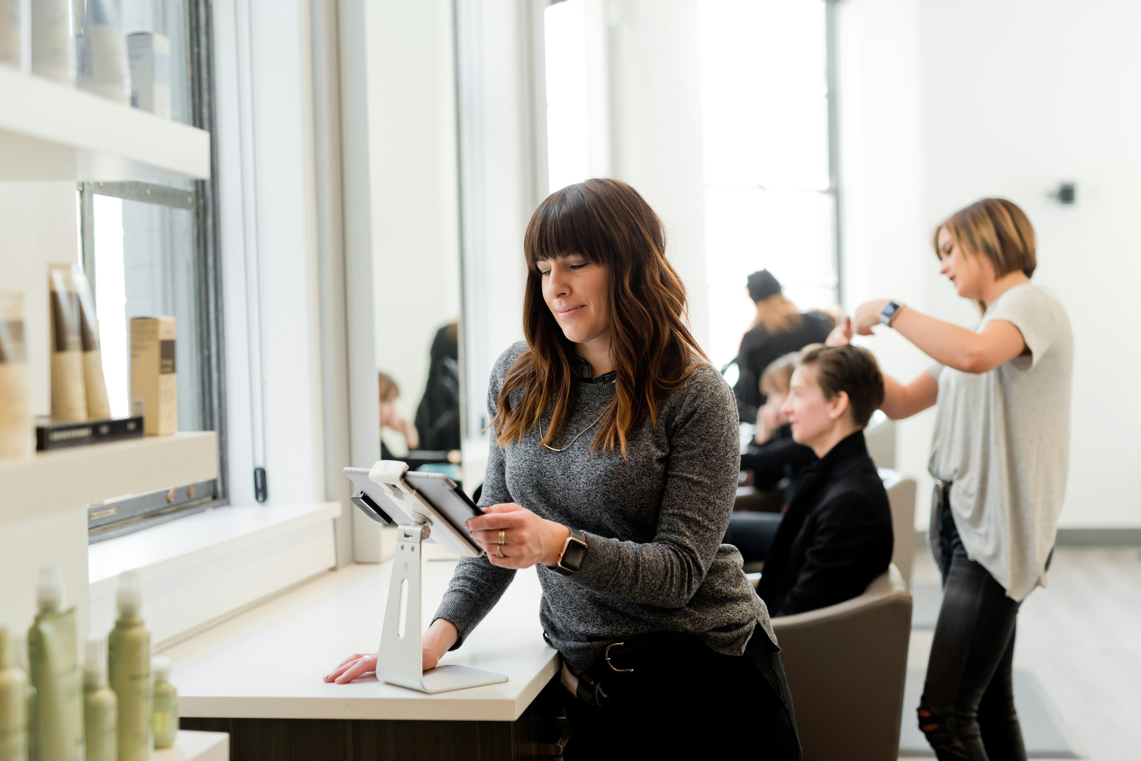 Woman in Gray Sweater Holding Tablet.jpg