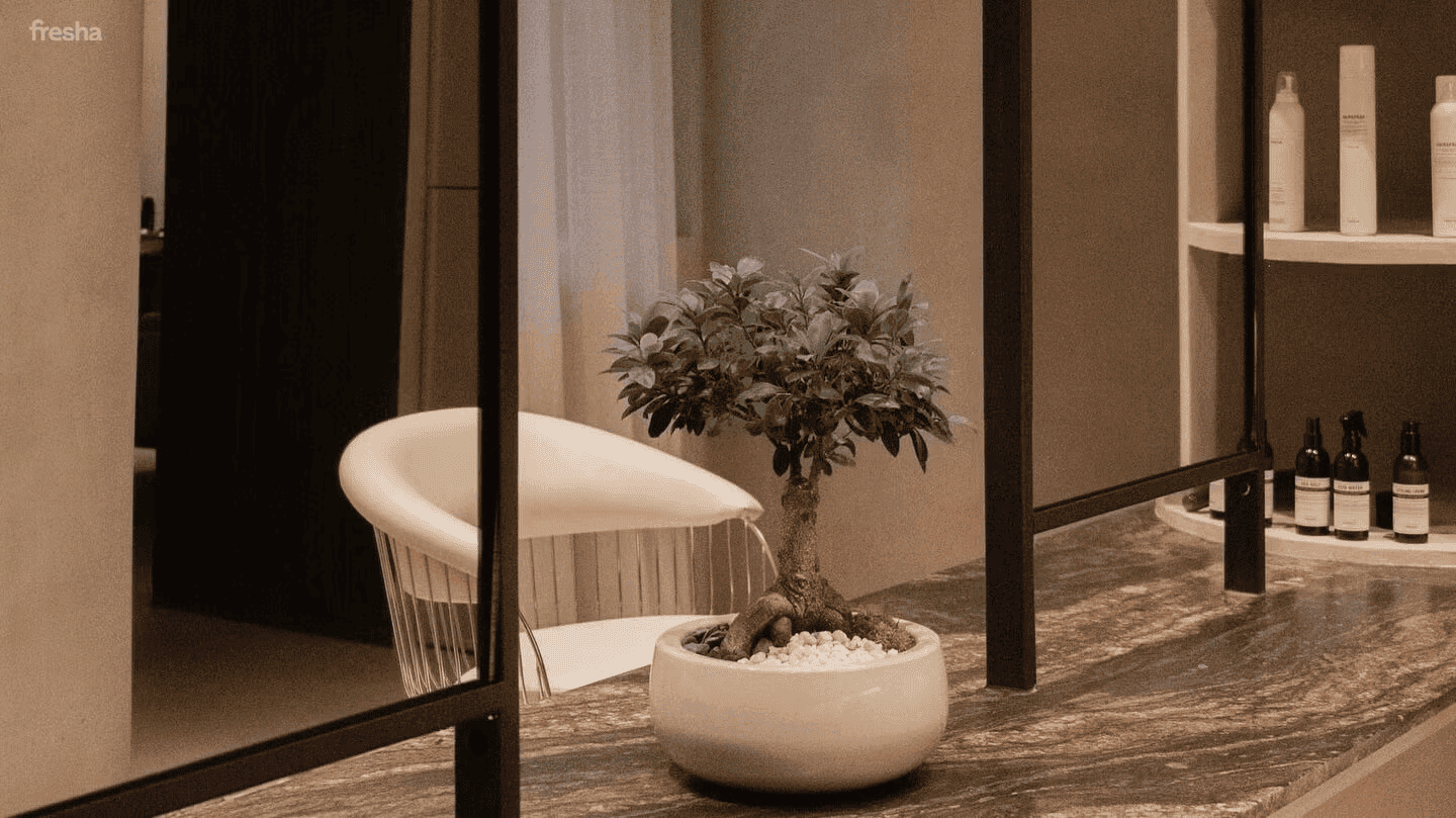neautral salon with white chair and bonsai tree on desk
