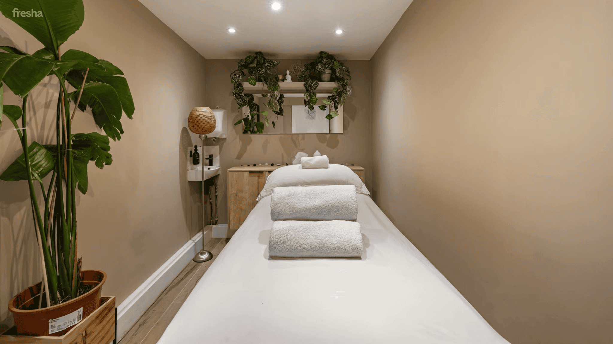 neutral coloured salon with white bed and towels