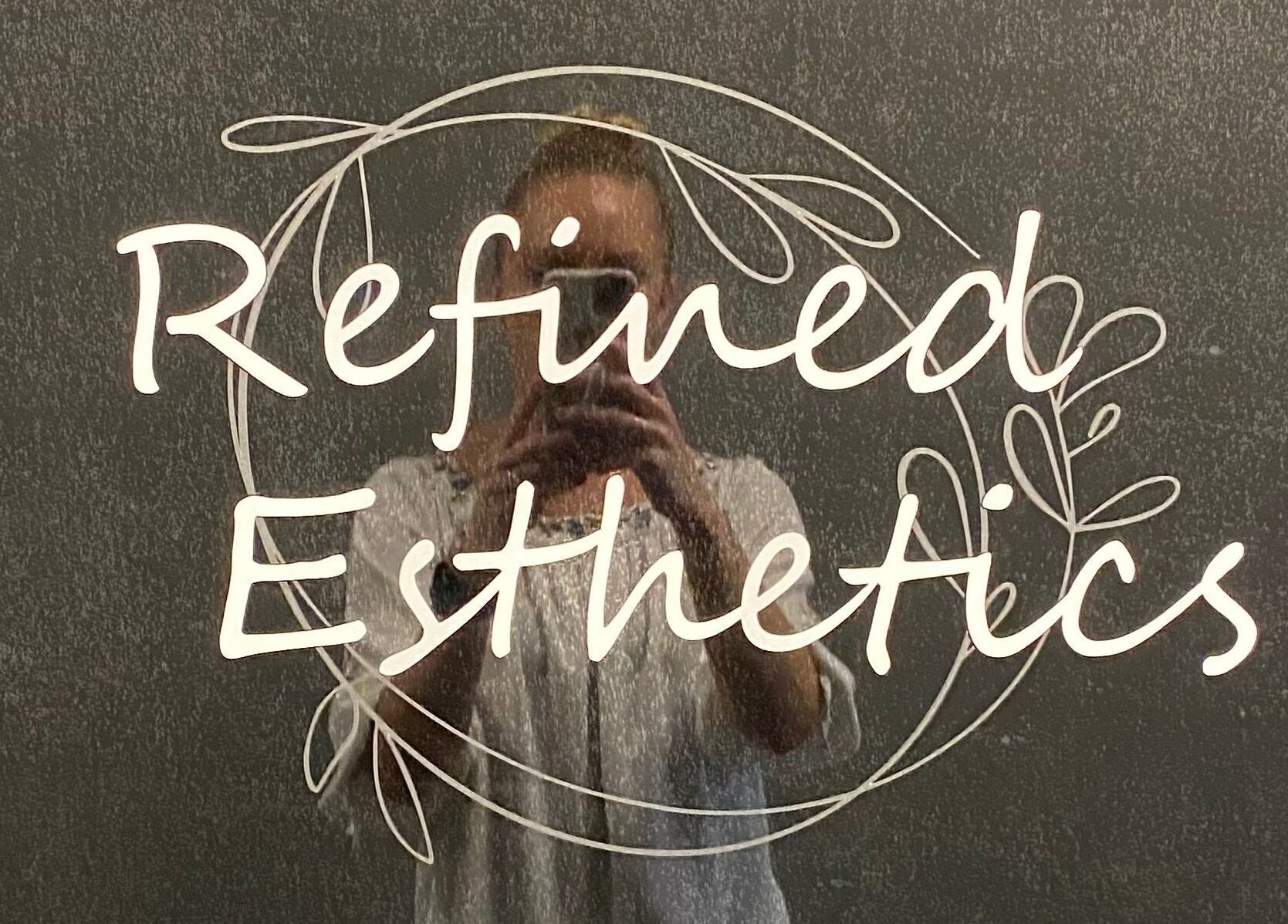 Refined Esthetics logo elegantly displayed with mirror reflection in Dekalb, Illinois, US.