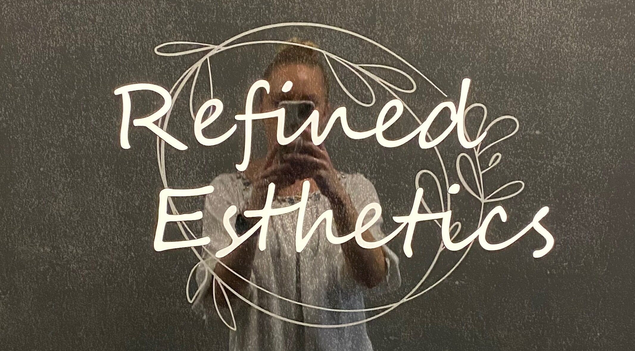 Refined Esthetics logo elegantly displayed with mirror reflection in Dekalb, Illinois, US.