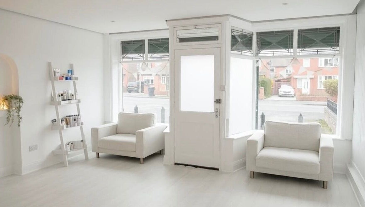 Bright, minimalist reception area at Bare Skin Clinic, Worsley, England, GB with cozy seating and natural light.