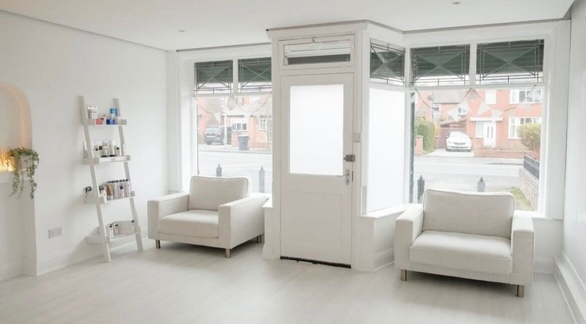 Bright, minimalist reception area at Bare Skin Clinic, Worsley, England, GB with cozy seating and natural light.