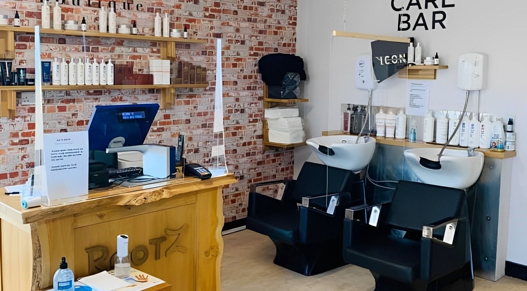 Inside the stylish Rootz Hair Studio in Woodbridge, England, GB showcasing modern wash stations and products.