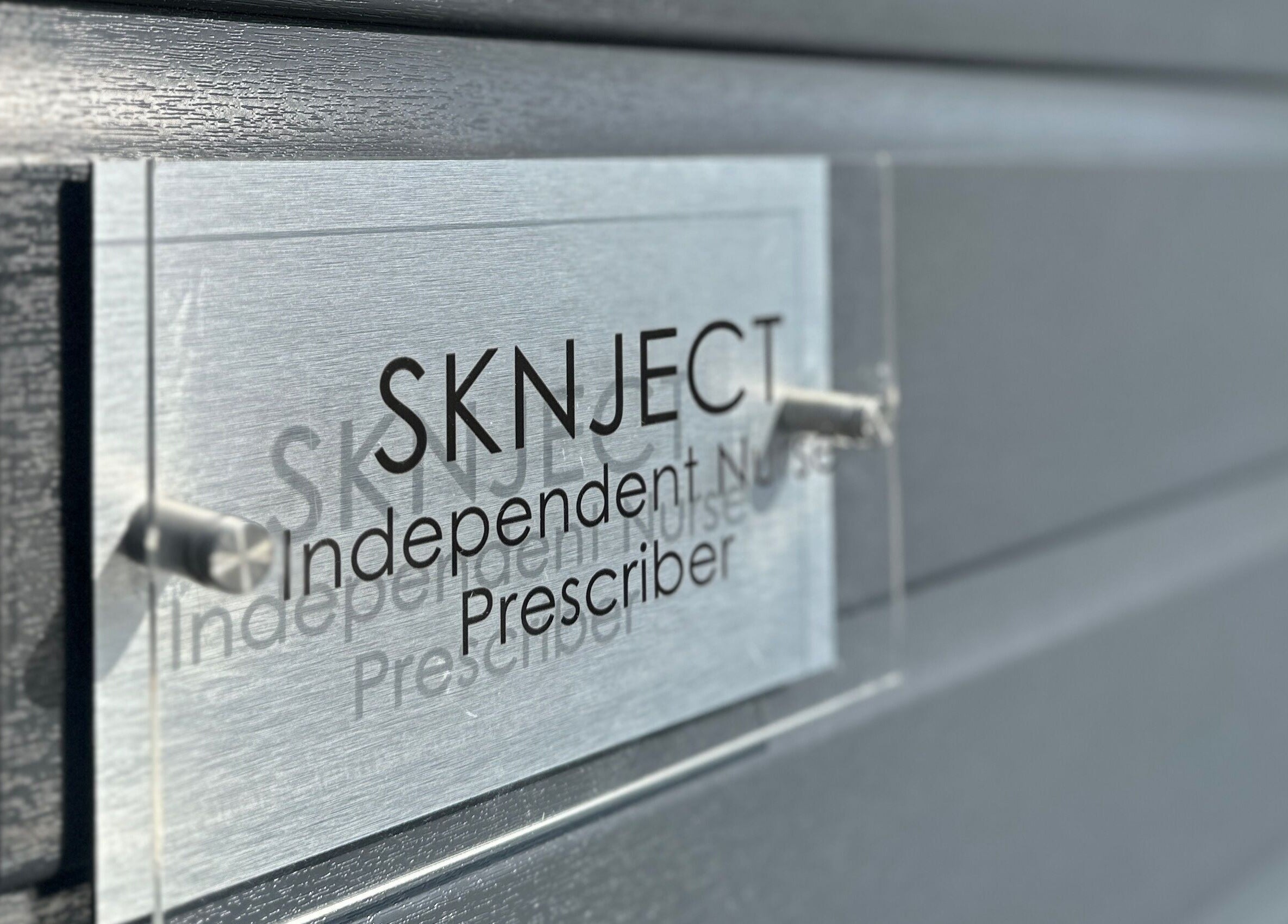 Sknject signage on a gray wall in Rotherham, England, GB, showcasing independent prescriber services.