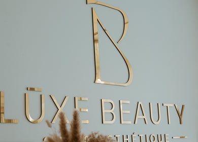 Lūxe Beauty Spa & Esthétique logo in gold, Clarence-Rockland, Ontario, CA enhancing wall decor.