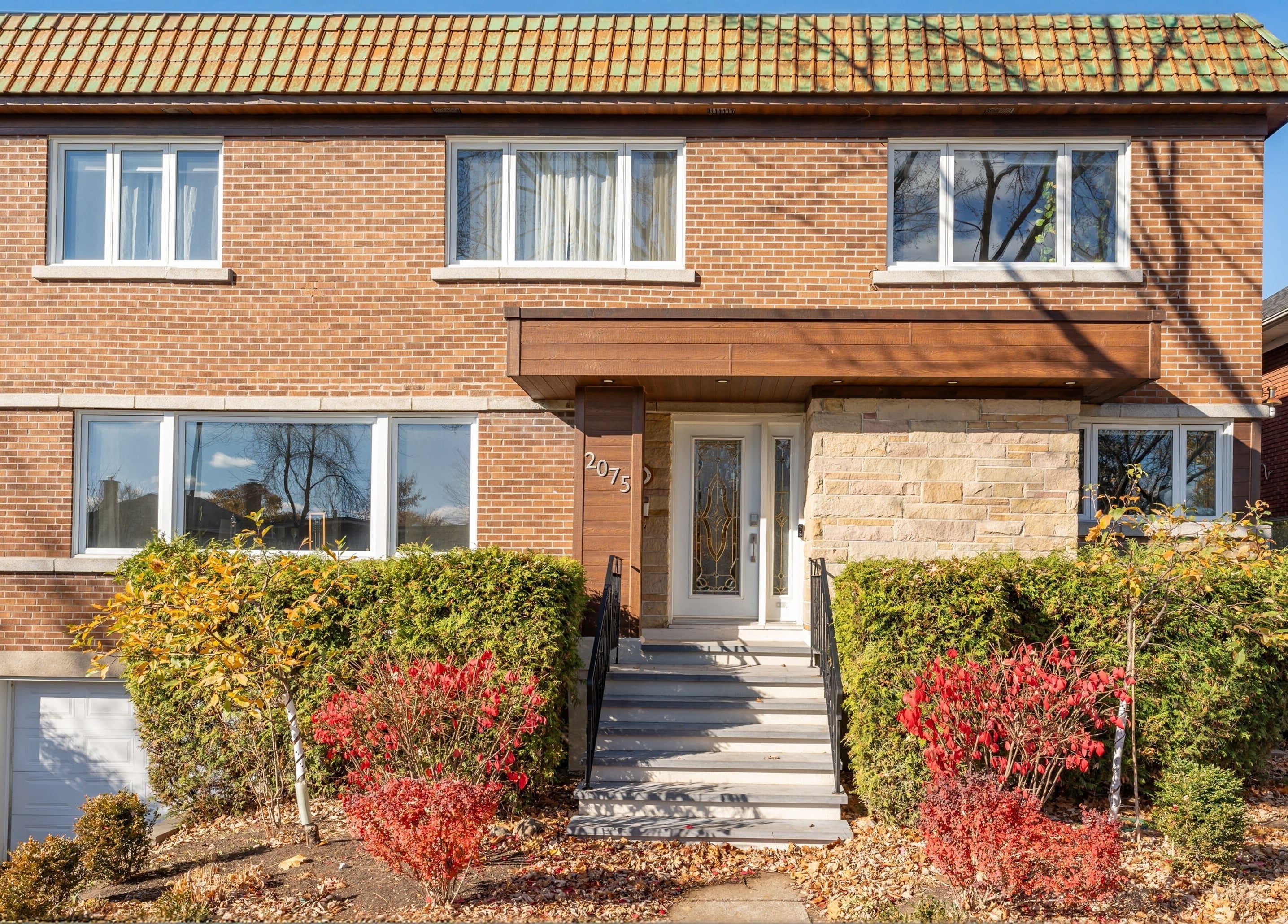 Façade de Vibrations Om - St-Laurent (de l'Église), Montréal, Québec, CA, avec briques et verdure.