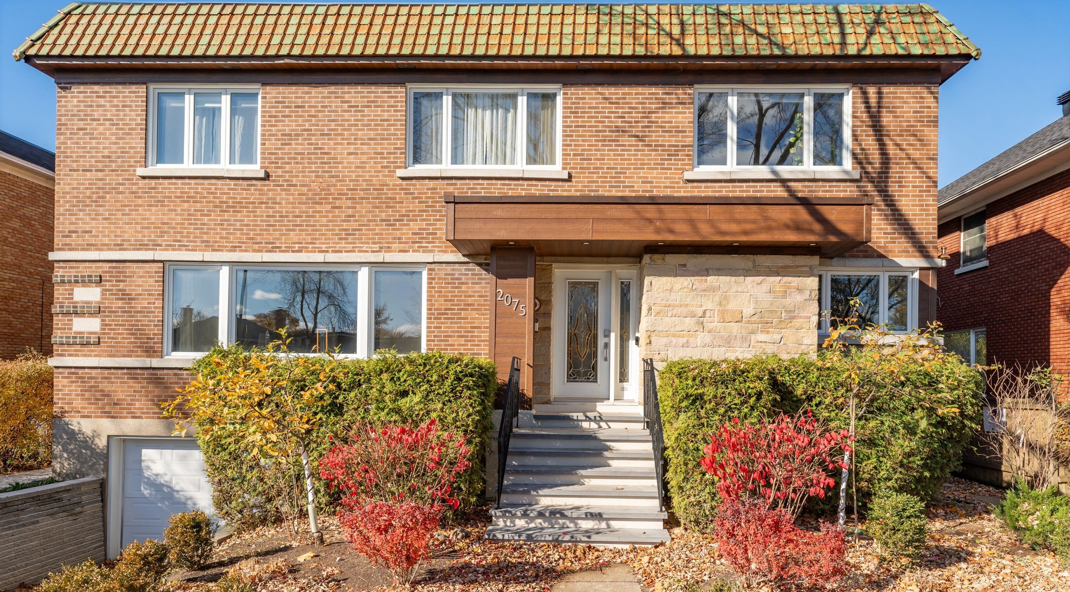 Façade de Vibrations Om - St-Laurent (de l'Église), Montréal, Québec, CA, avec briques et verdure.