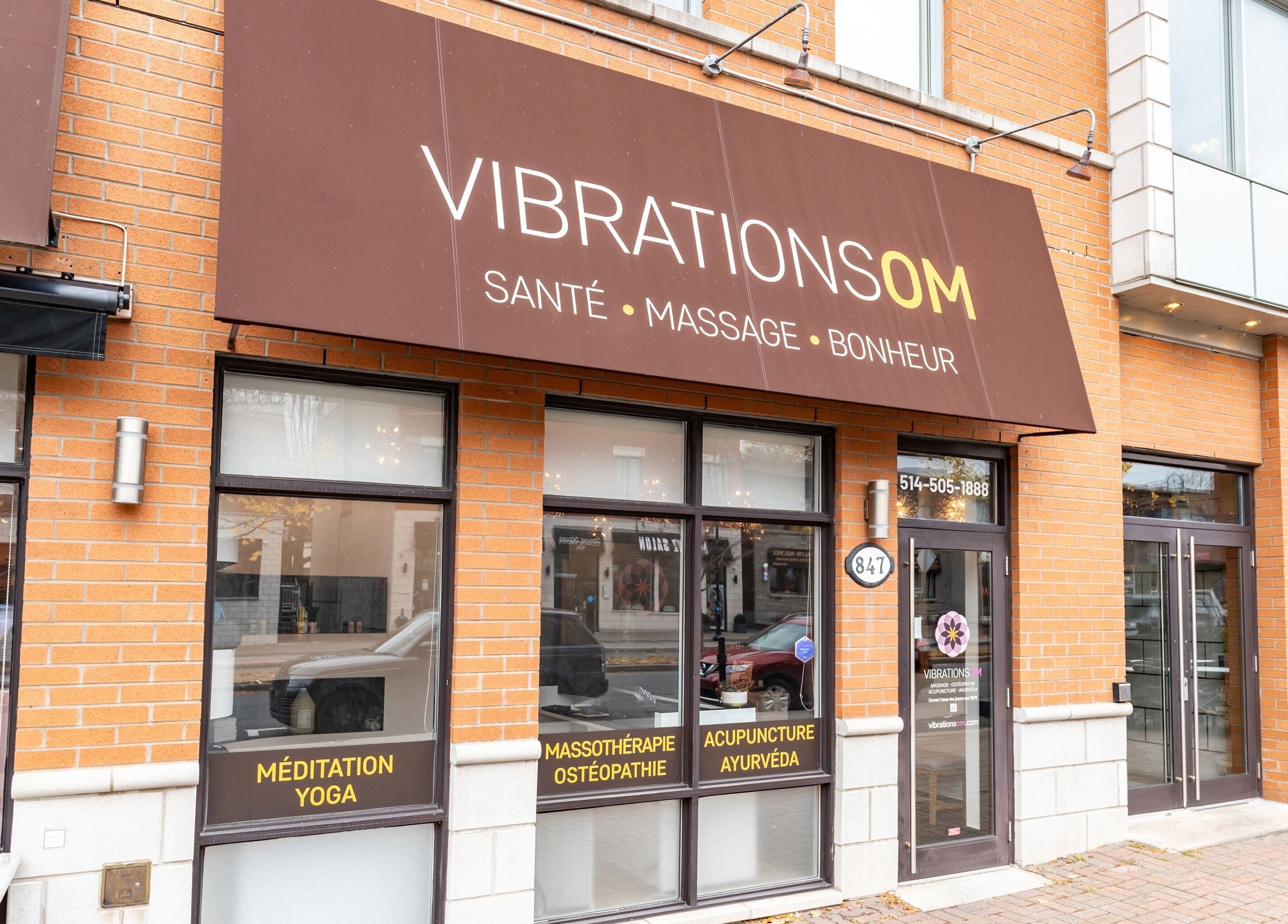 Entrée de Vibrations Om - St. Laurent (Décarie) à Montréal, Québec, CA avec enseigne extérieure marron.