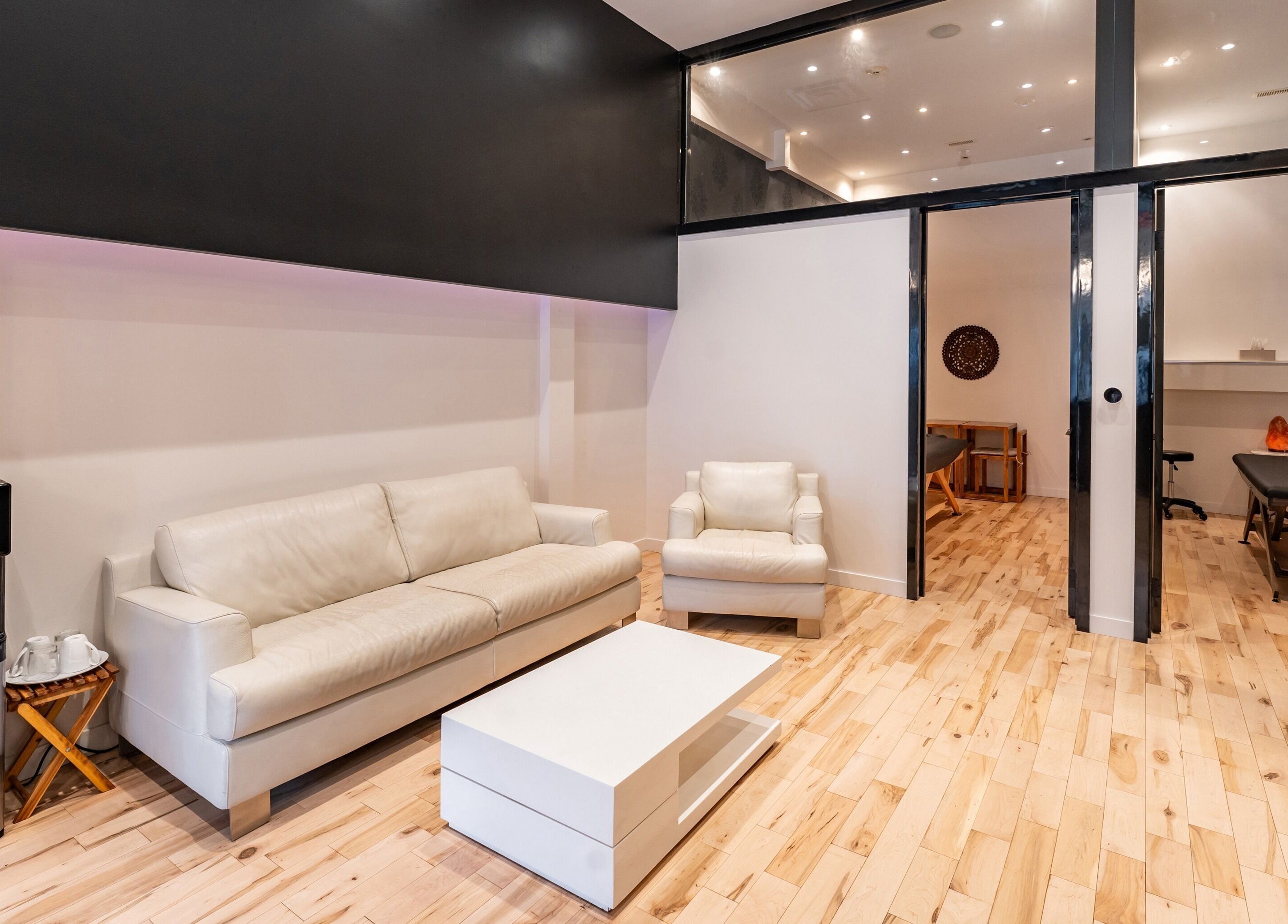 Salon moderne à Vibrations Om - St. Laurent (Décarie) à Montréal, Québec, CA avec canapé blanc.