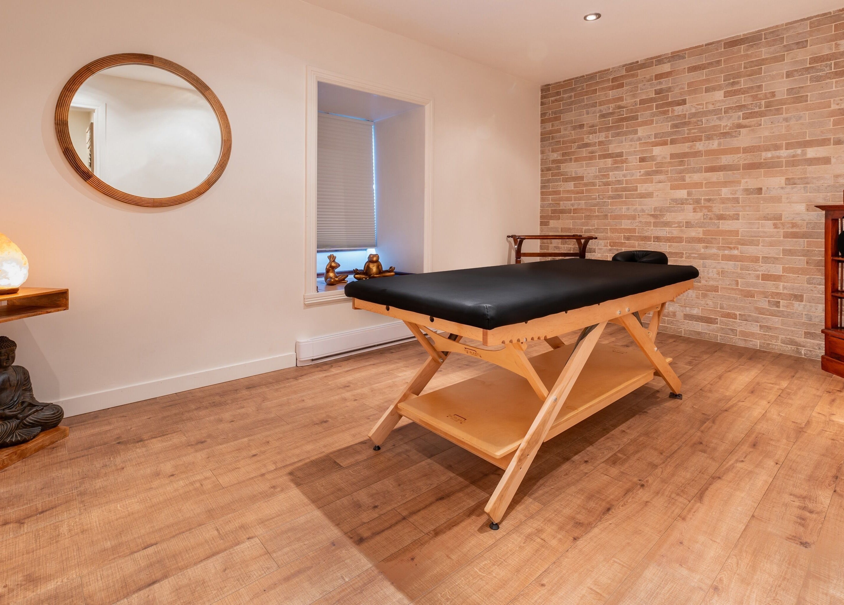 Salle de soins sereine à Vibrations Om - Pointe-Claire, Pointe-Claire, Québec, CA avec table et déco apaisante.