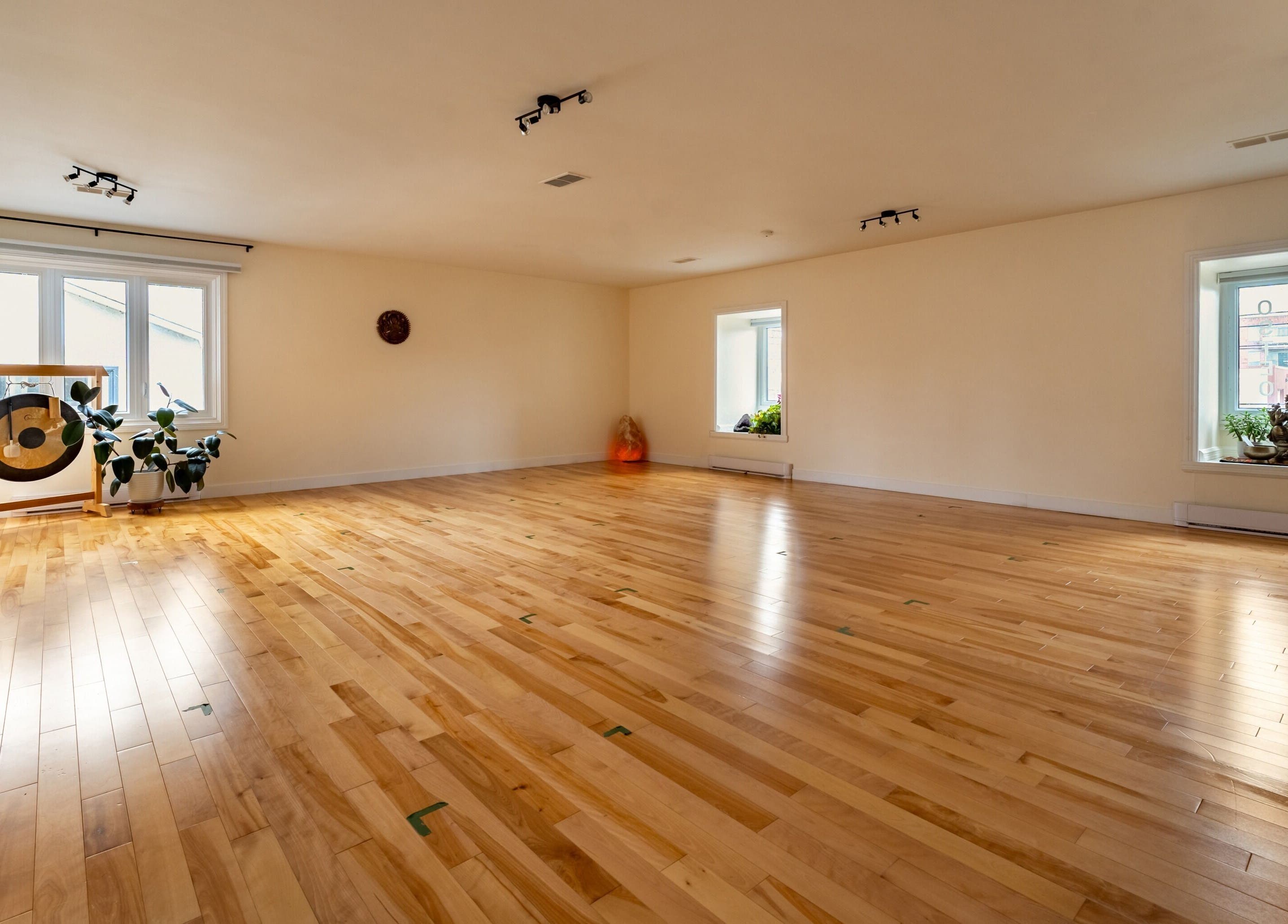 Studio lumineux de Vibrations Om - Pointe-Claire, Québec, CA, avec parquet en bois et gong.