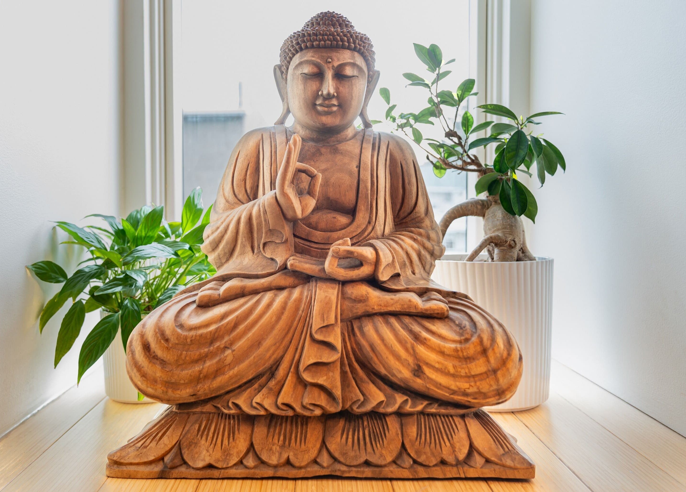 Statue de Bouddha en bois chez Vibrations Om - Pointe-Claire, offrant une ambiance zen à Pointe-Claire, Québec, CA.