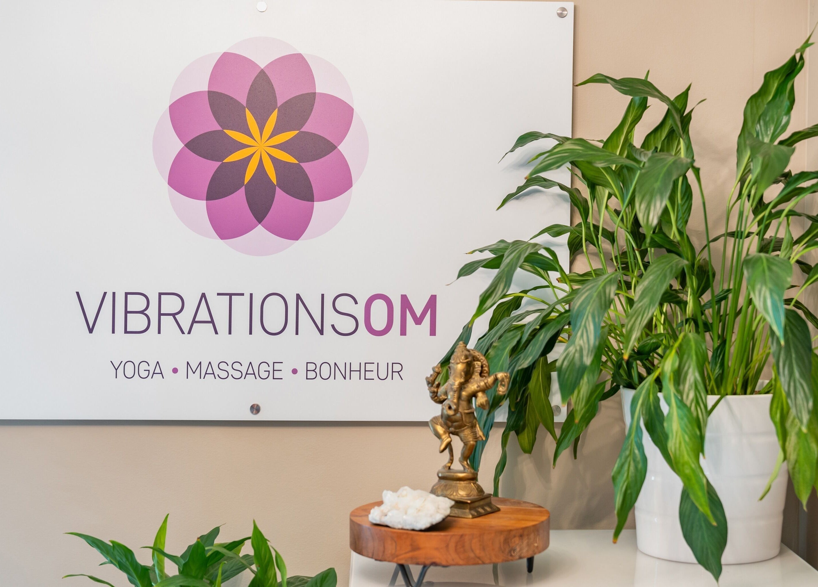 Décor paisible chez Vibrations Om - Pointe-Claire, avec plantes et statue, Québec, CA.