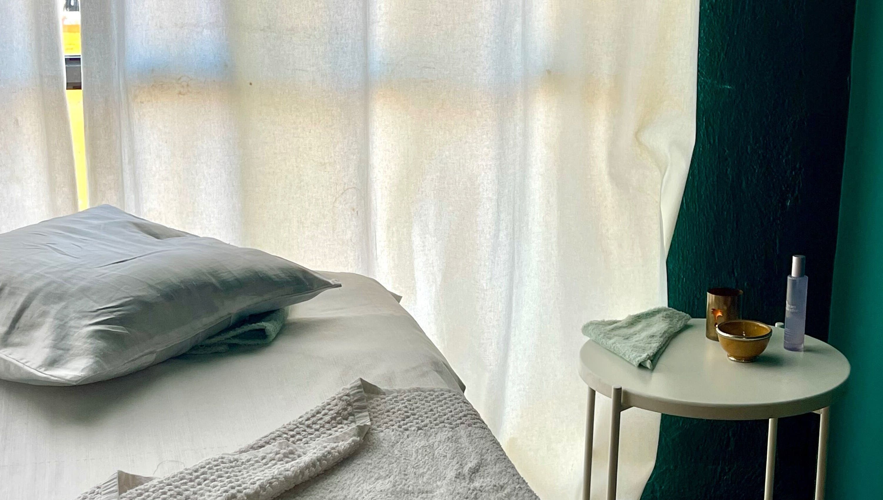 Cama de masaje en East Therapy, Barcelona, Catalunya, ES, con luz suave para una experiencia relajante.