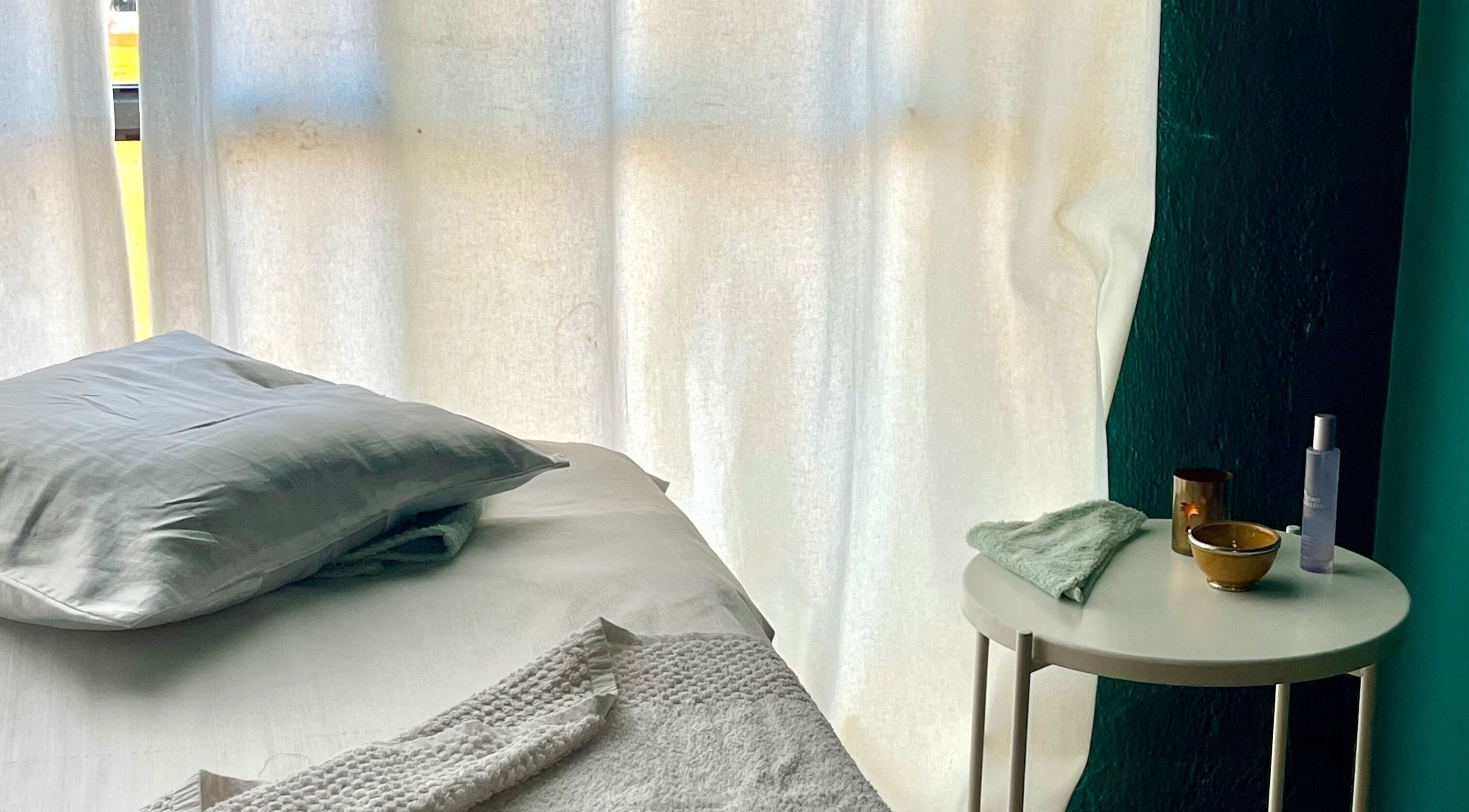 Cama de masaje en East Therapy, Barcelona, Catalunya, ES, con luz suave para una experiencia relajante.