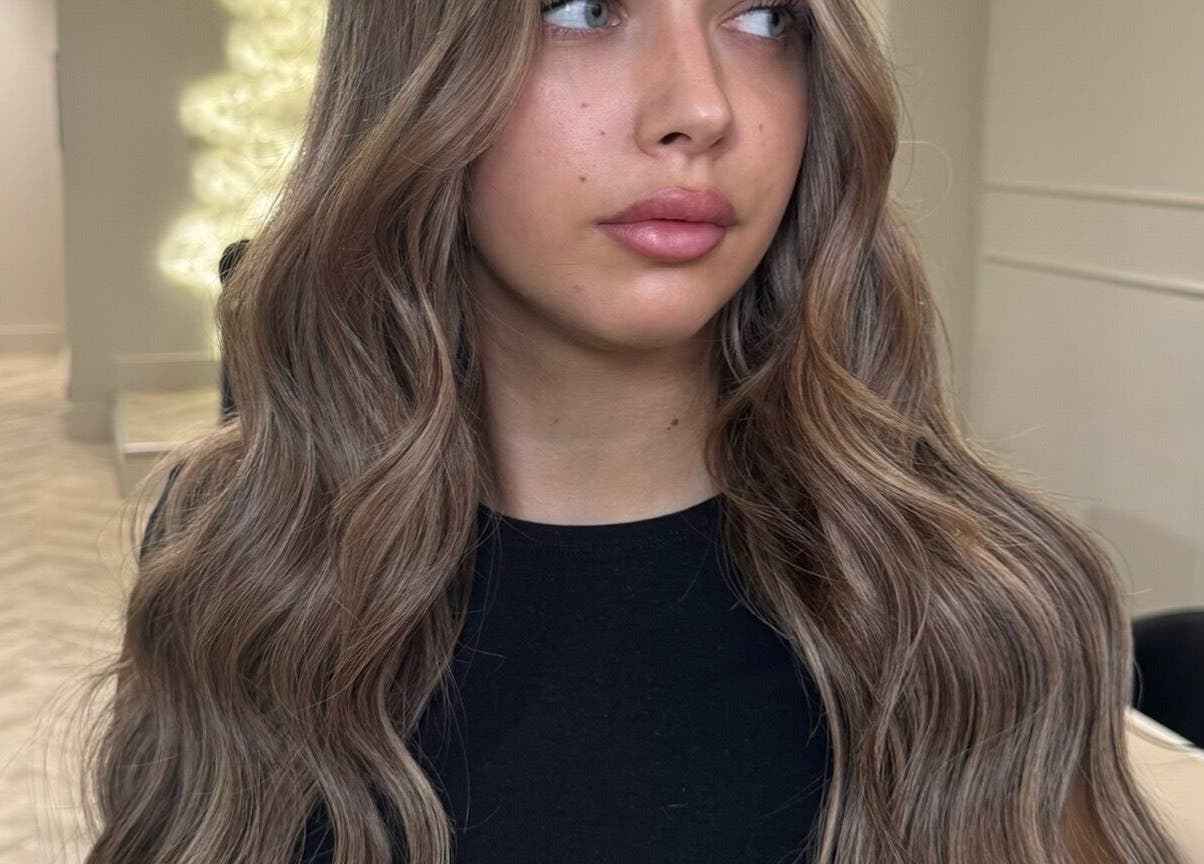 Woman with long, wavy hair at Mane Muse salon in Pendlebury, England, GB.