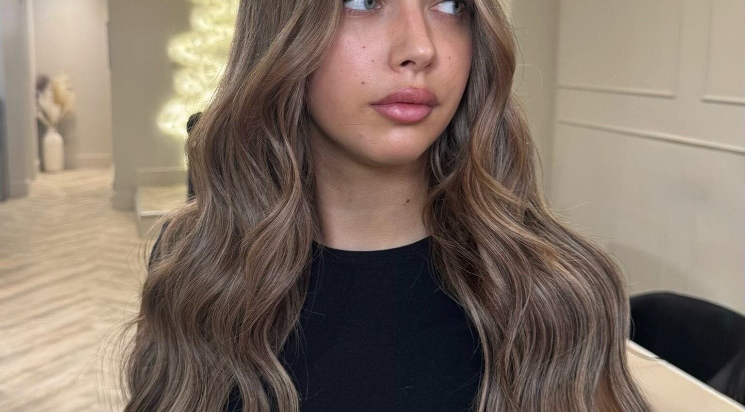 Woman with long, wavy hair at Mane Muse salon in Pendlebury, England, GB.