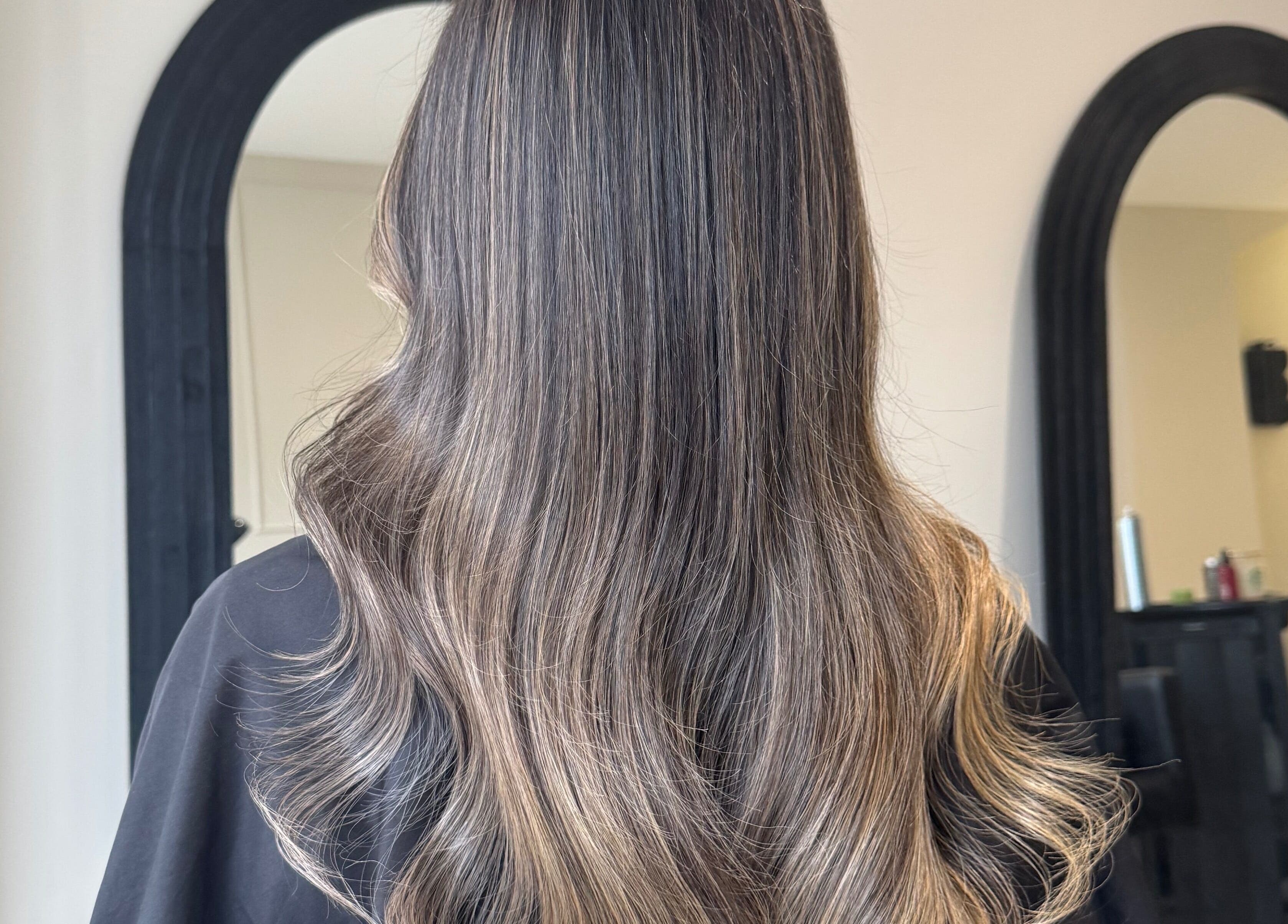 Beautiful long hair styled at Mane Muse salon, Pendlebury, England, GB, in front of a stylish mirror.