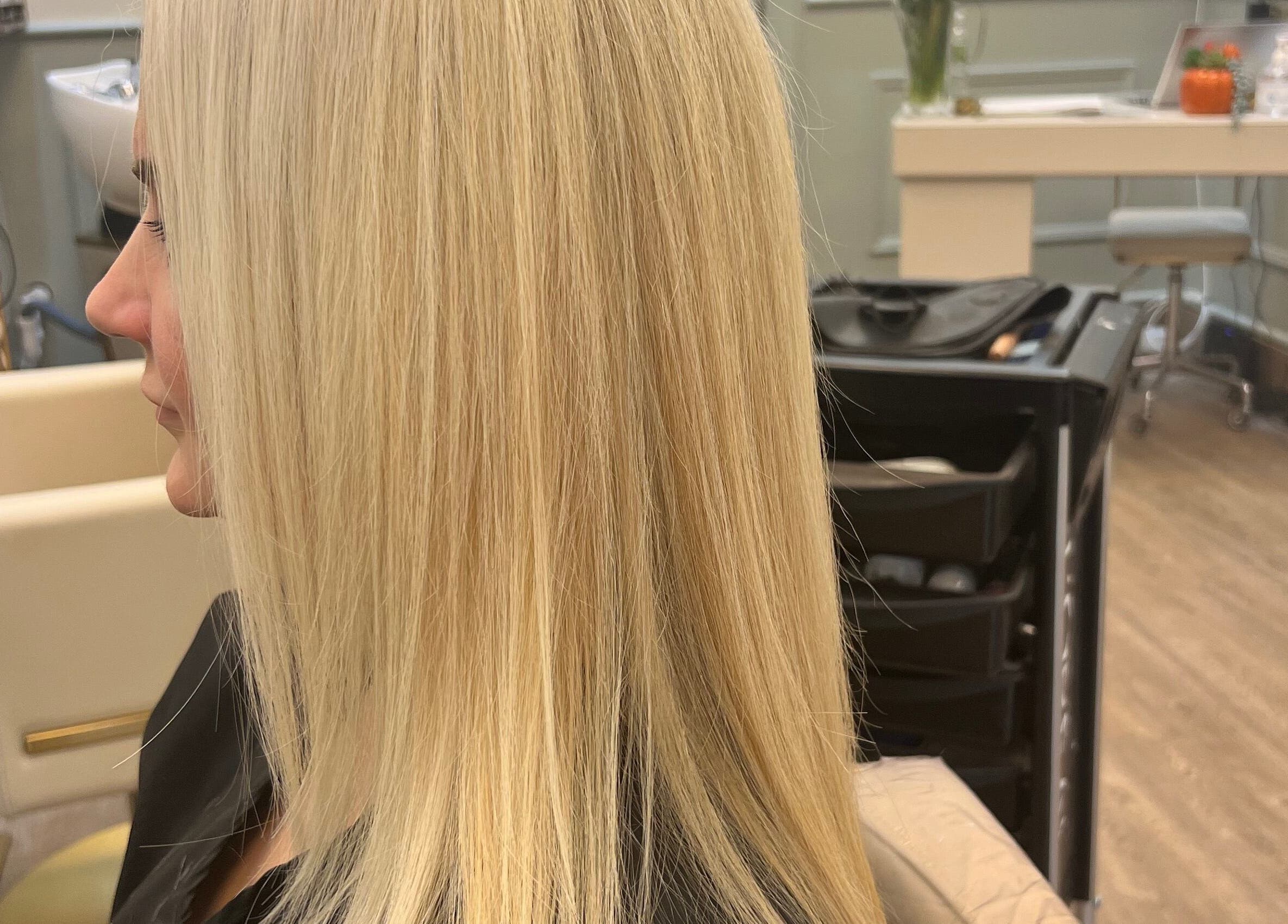 Woman with sleek blonde hair at Violets salon, Callander, Scotland, GB.