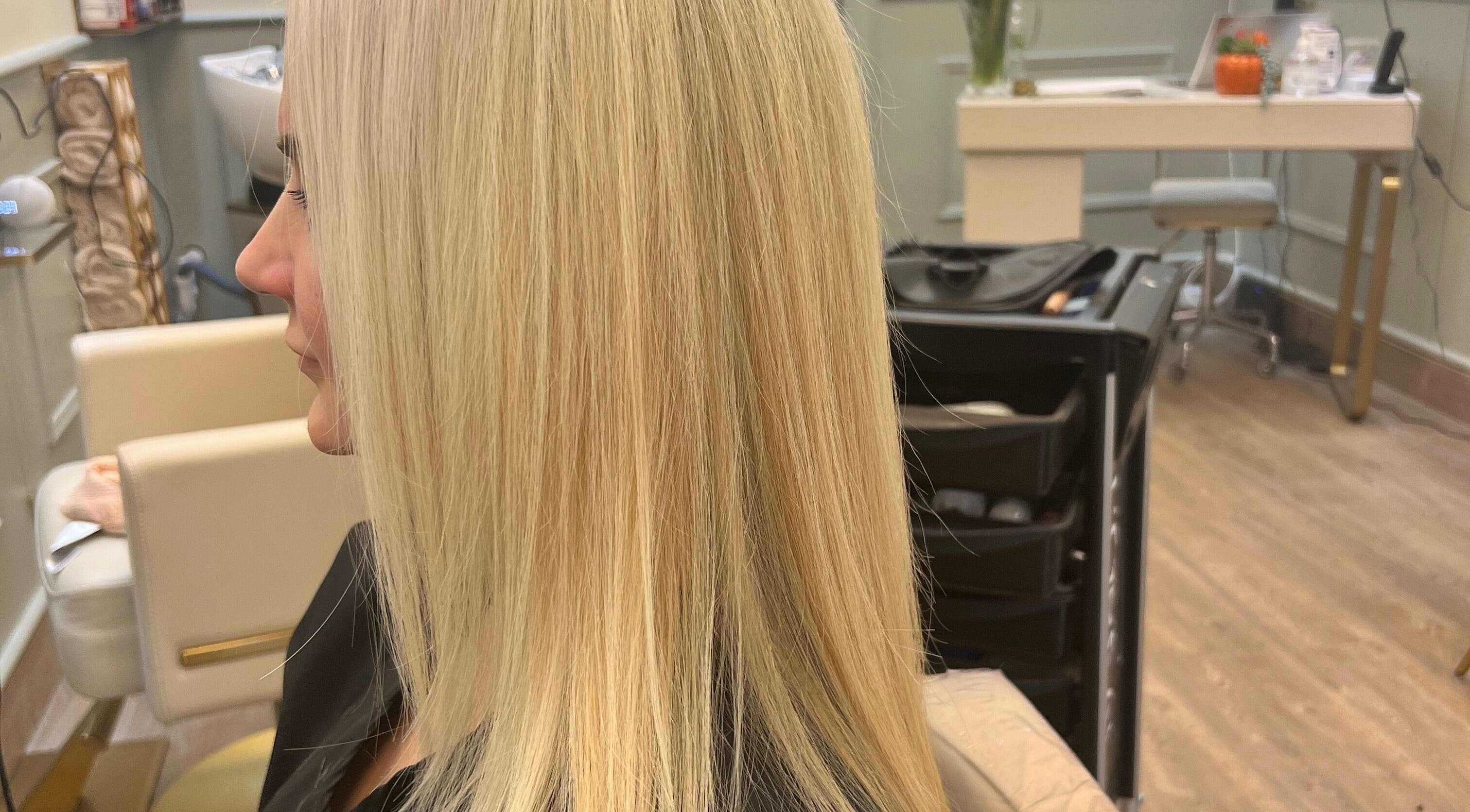 Woman with sleek blonde hair at Violets salon, Callander, Scotland, GB.
