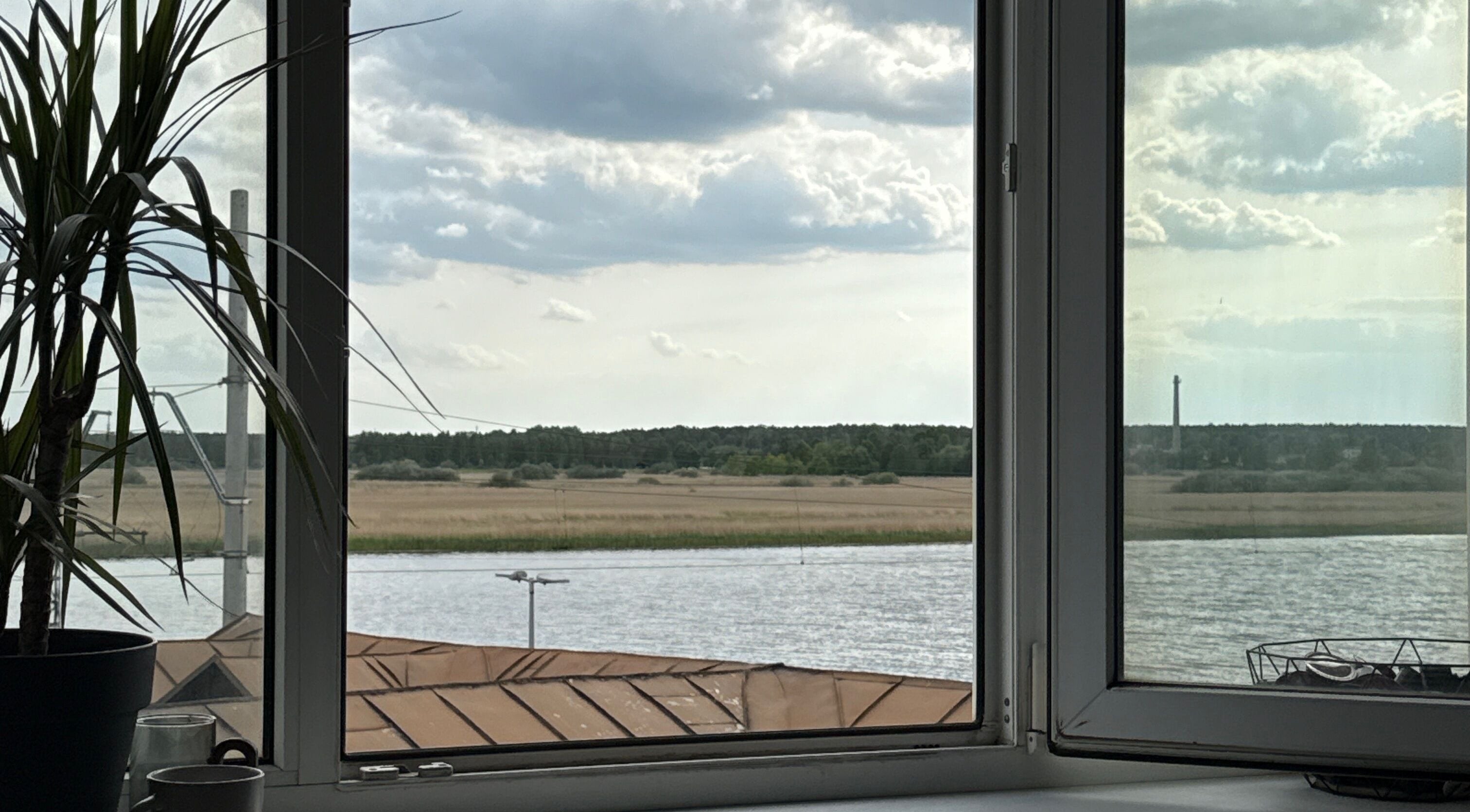 Calm river and trees seen through Adelenailsstudio window, Jūrmala, Latvija, LV.