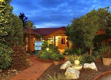 Entrance to Kimi Ora Day Spa, surrounded by lush greenery, Kaiteriteri, Tasman, NZ at twilight.