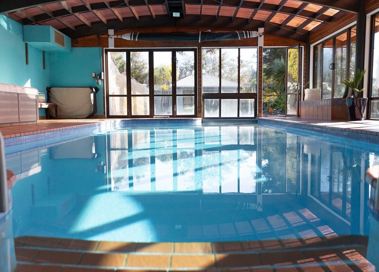 Indoor pool with serene views at Kimi Ora Day Spa, Kaiteriteri, Tasman, NZ, featuring natural light and relaxation.