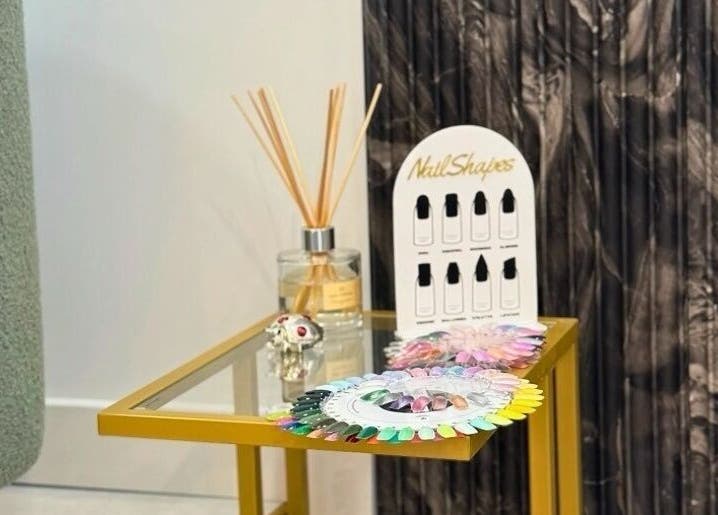 Nail polish samples and diffuser on a gold table at Biab Nails Balham in London, England, GB.