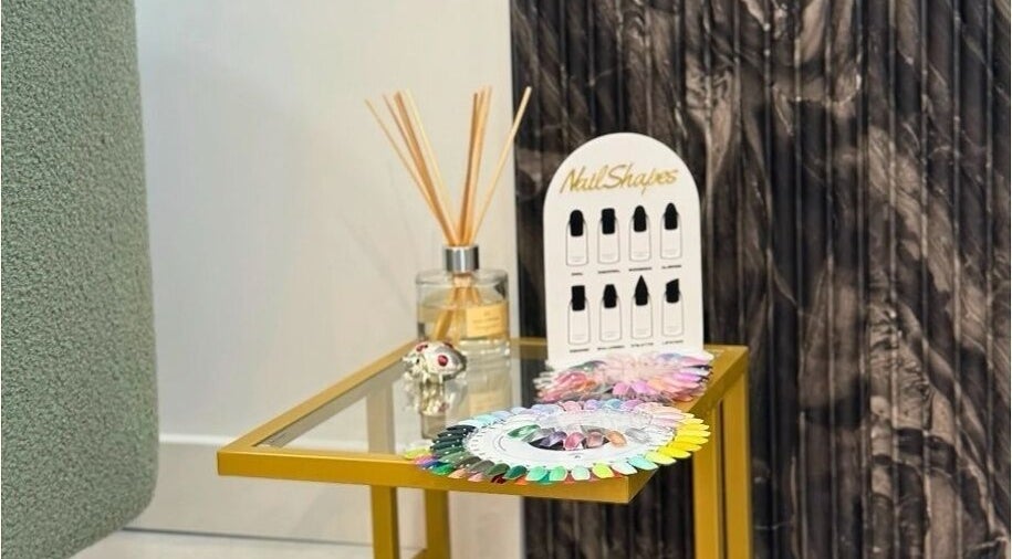 Nail polish samples and diffuser on a gold table at Biab Nails Balham in London, England, GB.