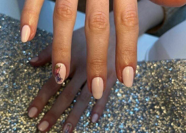 Beautiful nail art with floral design at Biab Nails Balham, London, England, GB on a sparkly surface.