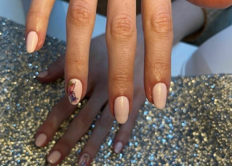 Beautiful nail art with floral design at Biab Nails Balham, London, England, GB on a sparkly surface.