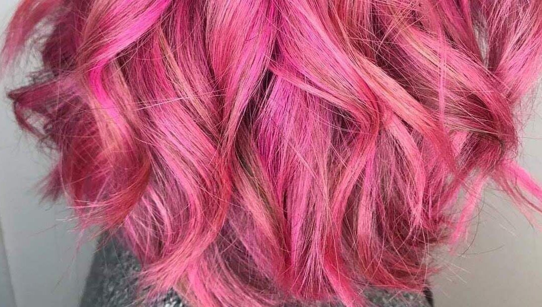 Vibrant pink hair styled into waves at Pink & Pampered Salon, Chicago, Illinois, US.