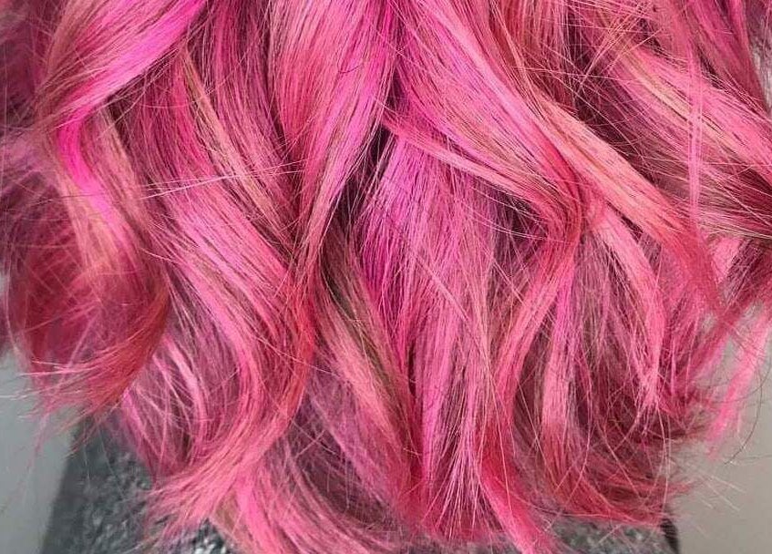 Vibrant pink hair styled into waves at Pink & Pampered Salon, Chicago, Illinois, US.