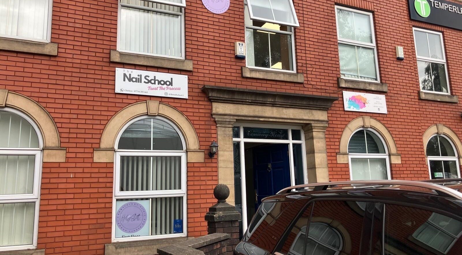 The Nail School facade at Middleton, England, GB with its welcoming entrance and red brick exterior.