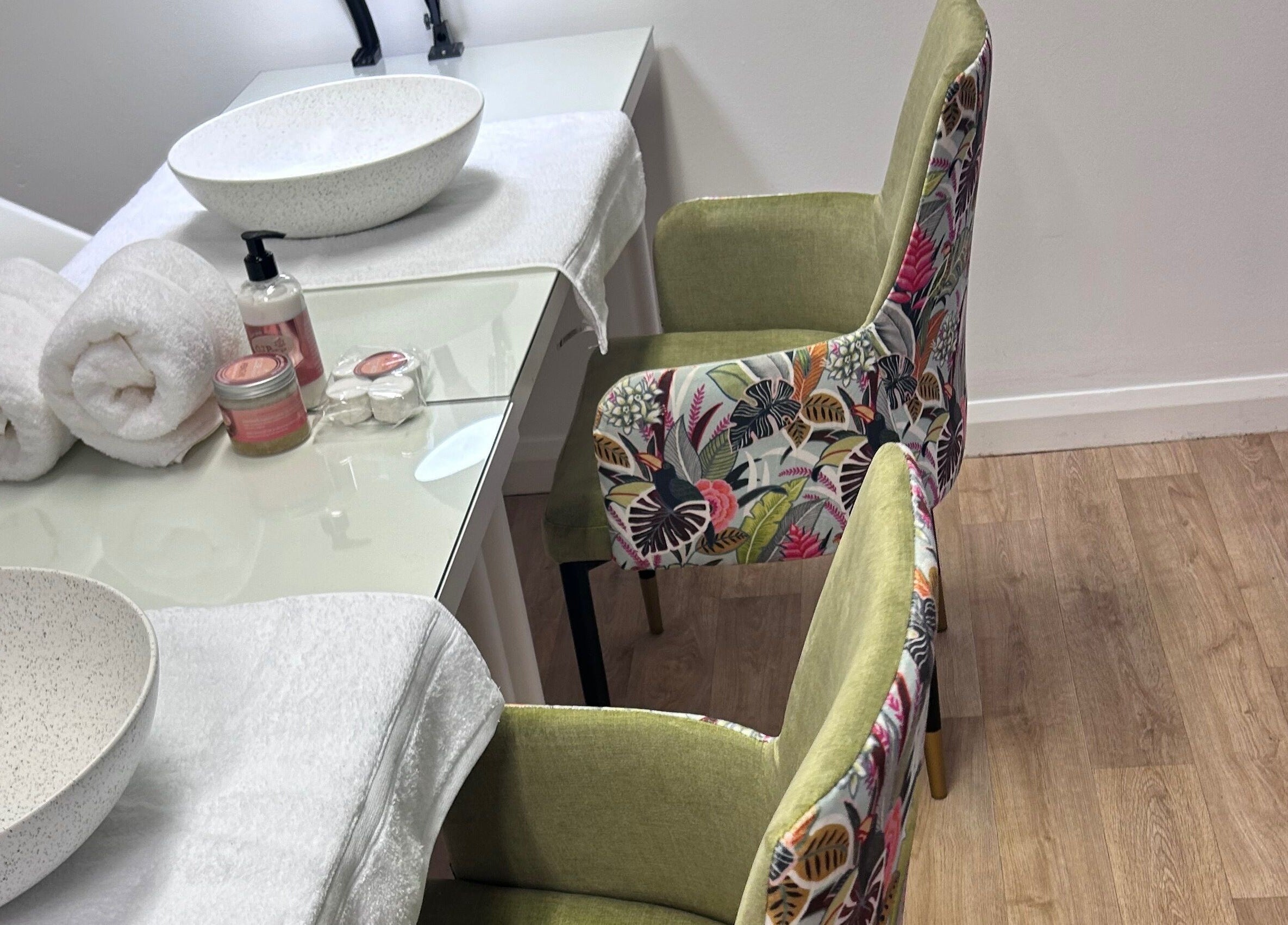 Chic nail setup at The Nail School, Middleton, England, GB with floral chairs and luxury towels.