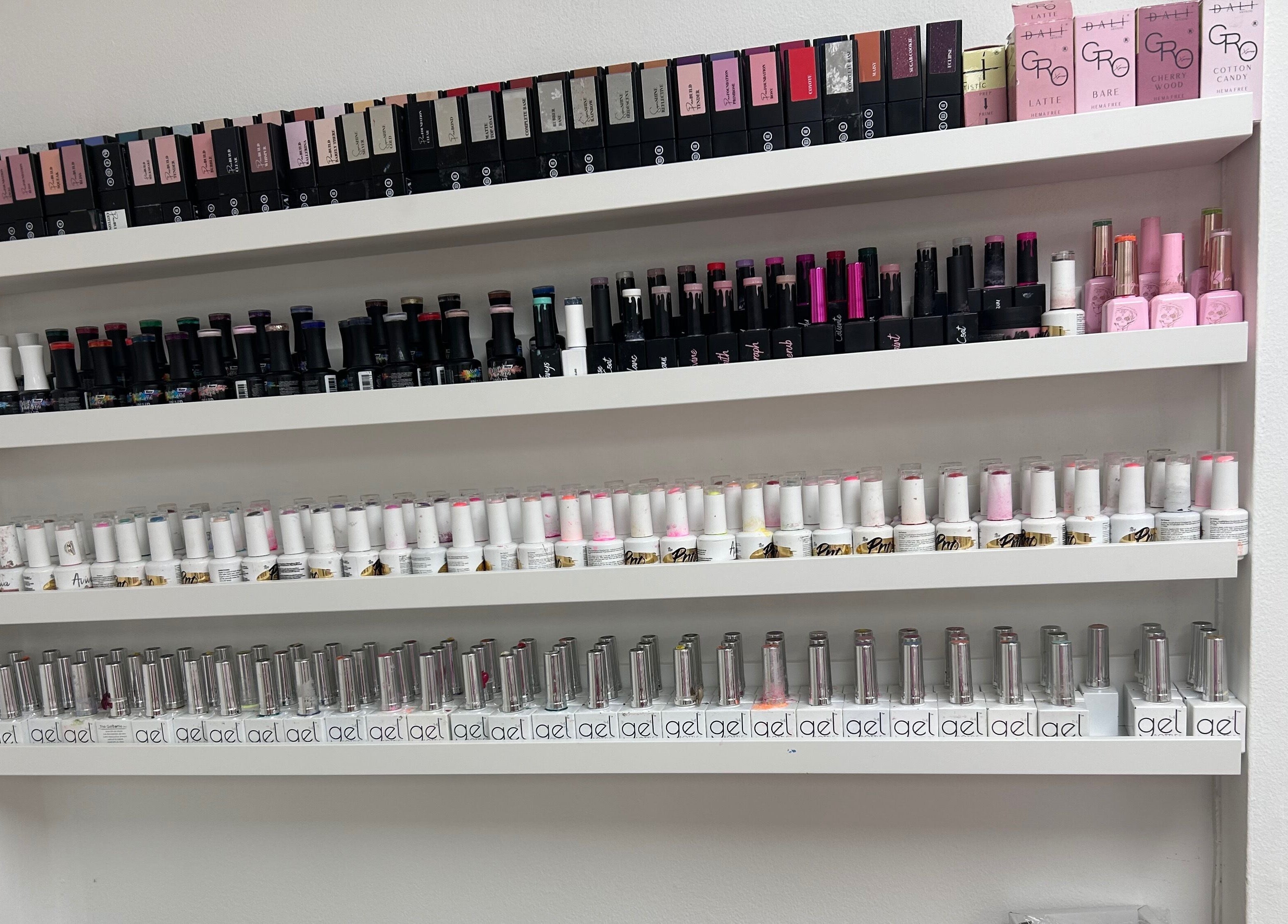 Vibrant nail polish collection at The Nail School in Middleton, England, GB, showcasing various shades and brands.