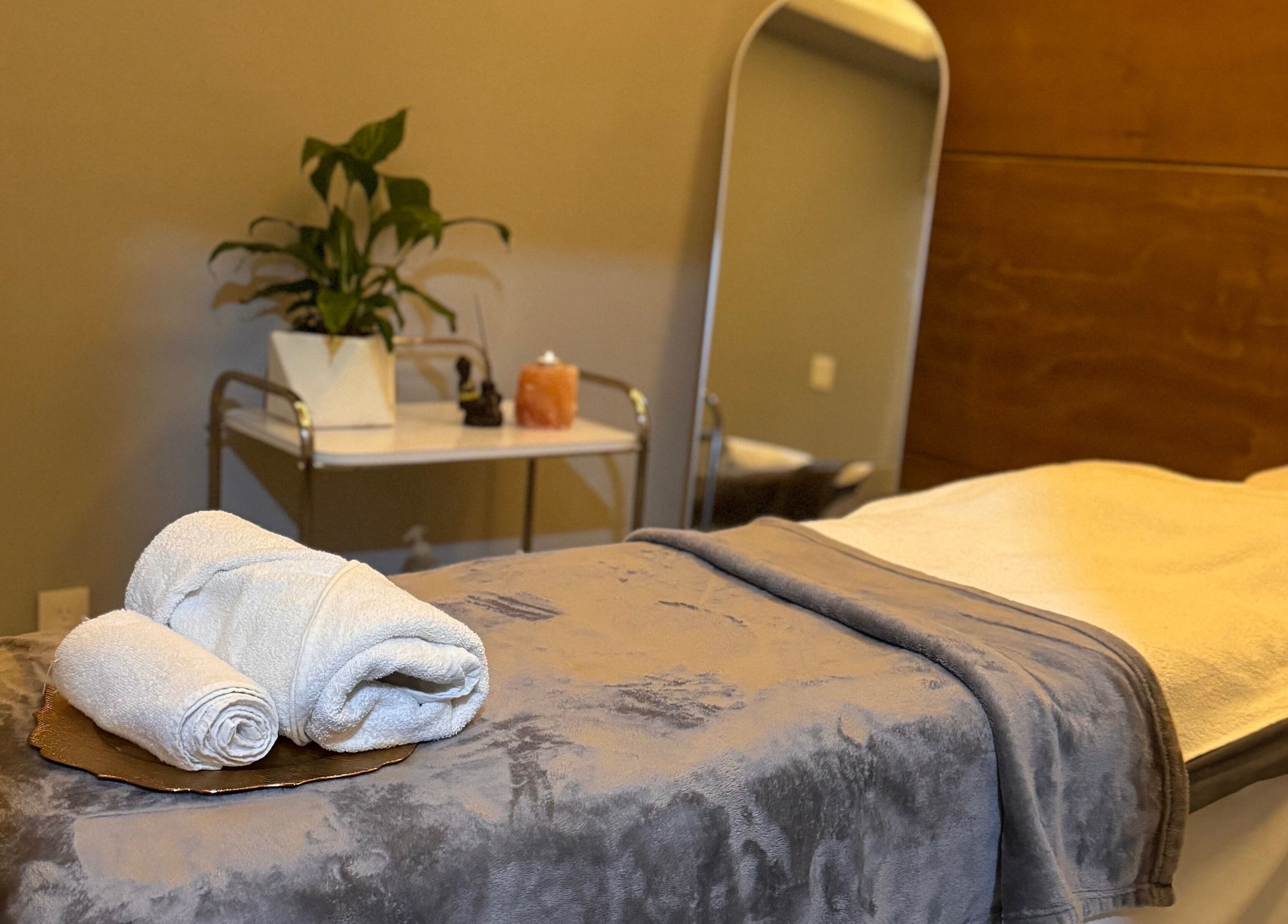 Camilla de masaje en Liriospa, Pachuca De Soto, Hidalgo, MX con toallas blancas y plantas decorativas.