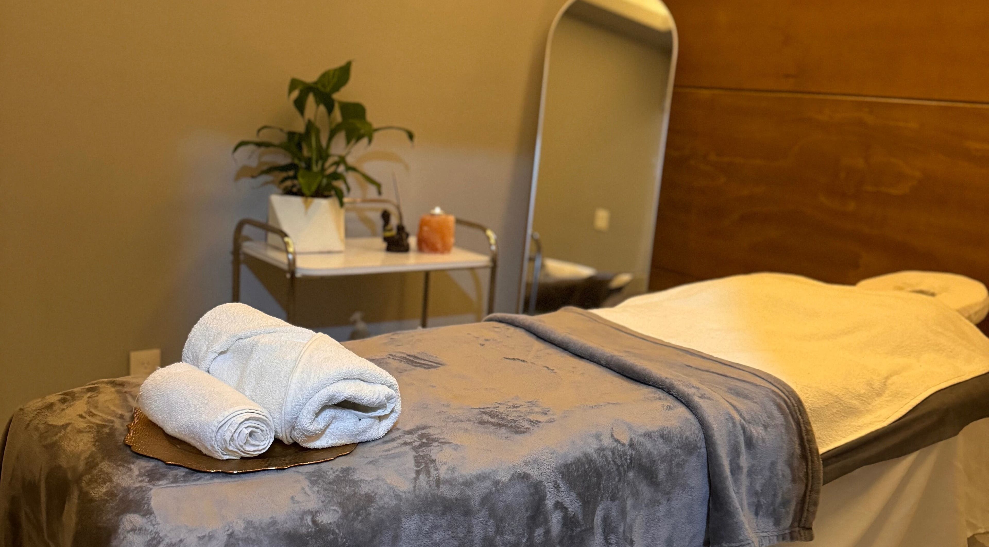 Camilla de masaje en Liriospa, Pachuca De Soto, Hidalgo, MX con toallas blancas y plantas decorativas.