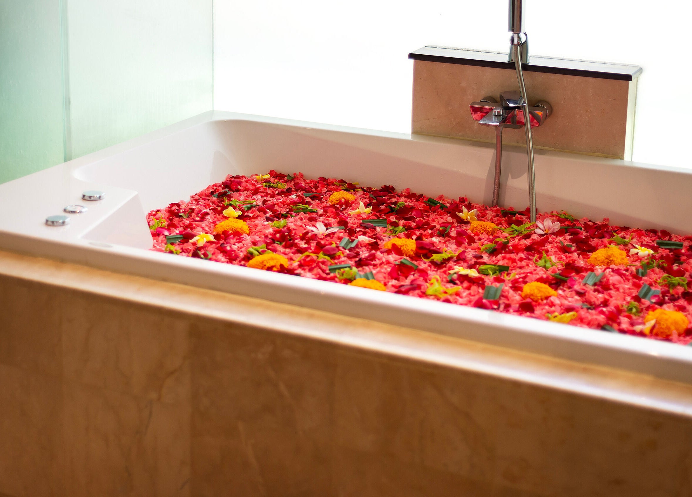 Luxurious bathtub with vibrant petals at Jivana Spa, Bali, Bali, ID.