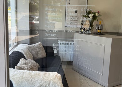 Cozy seating area at Hagon Hair & Beauty Ltd in Brighton And Hove, England, GB with opening hours displayed.