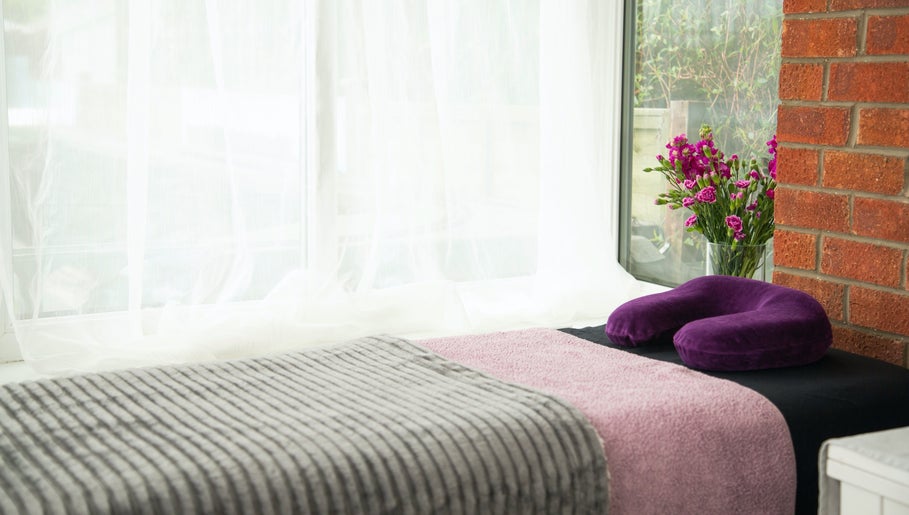 Relaxing massage setup at Sarah Sharp Massage, Copmanthorpe, England, GB with cozy linens and vibrant flowers.