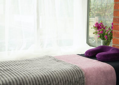 Relaxing massage setup at Sarah Sharp Massage, Copmanthorpe, England, GB with cozy linens and vibrant flowers.