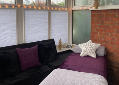 Inviting massage room at Sarah Sharp Massage, Copmanthorpe, England, GB, with plush pillows and fairy lights.
