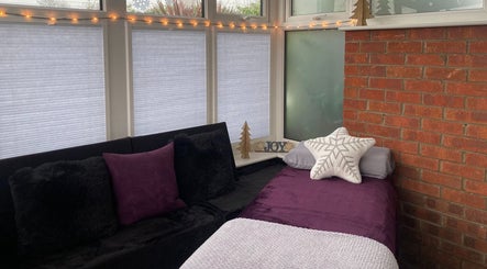 Inviting massage room at Sarah Sharp Massage, Copmanthorpe, England, GB, with plush pillows and fairy lights.