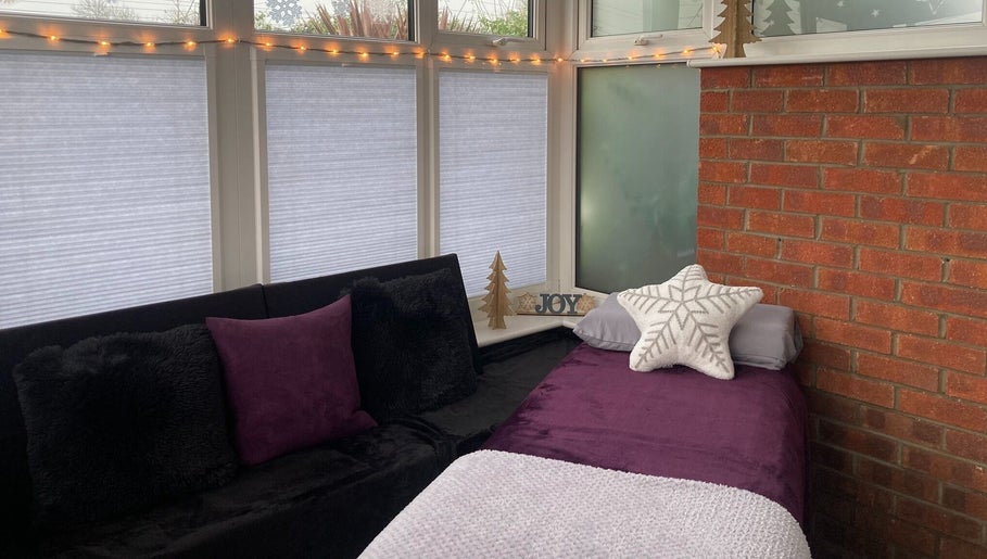 Tranquil massage room at Sarah Sharp Massage in Copmanthorpe, England, GB with soft lighting and cushions.