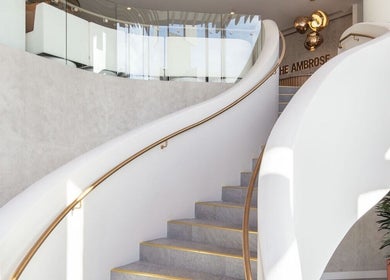 Elegant spiral staircase at SYLKSKIN Milton, Queensland, AU, embodying modern design and sophistication.