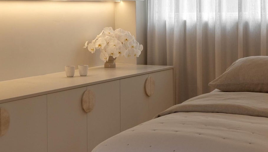 Elegant spa room at Joanna Newham Skin Health, Avalon Beach, New South Wales, AU with soft lighting and orchids.