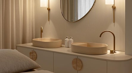 Chic vanity at Joanna Newham Skin Health, Avalon Beach, New South Wales, AU showcasing dual sinks and gold fixtures.