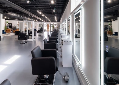 Modern salon interior at Studio LaSalle in DENTON, United States, US showcasing sleek black chairs and bright mirrors.